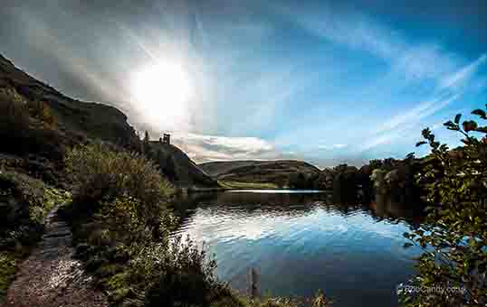 <p>Looking across the pond to a ruin on a hill</p>