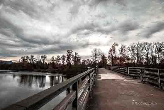 <p>A lone figure stands on an empty bridge</p>