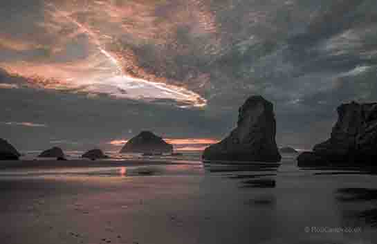 <p>The sunset reflecting off the wet sand with Face Rock.</p>