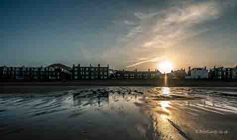 <p>Sunset over a beach with village</p>